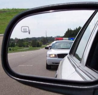 Police car in rear view mirror